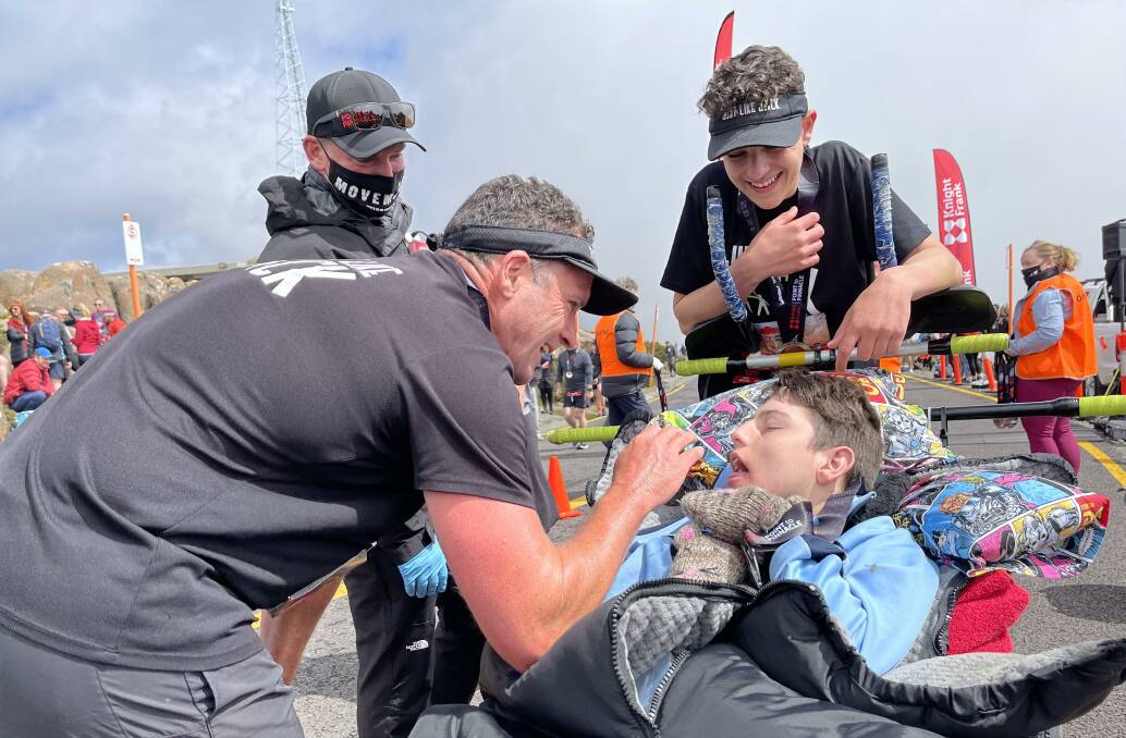 CELEBRATION: Jack Duffy, with his father Chris and older brother Xavier, shortly after crossing the Point to Pinnacle finish line on top of Mount Wellington. Picture: Supplied.