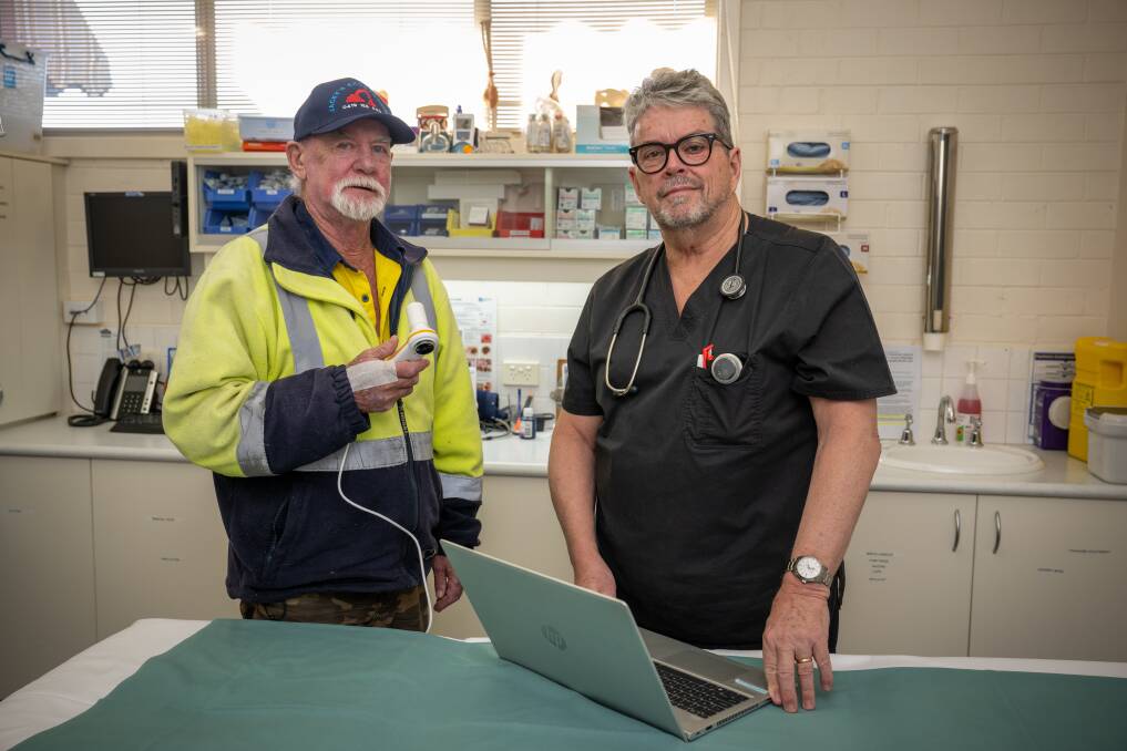 Graeme Blythe, holding a tool used in a lung capacity test, with Dr Andrew Jackson who runs a medical nicotine vaping program in Launceston. Pictures by Paul Scambler