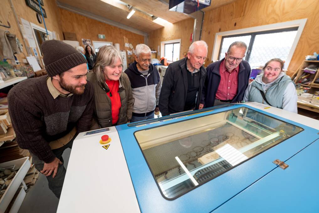 Community members gather around the new laser cutter in Rocherlea. Picture by Phillip Biggs