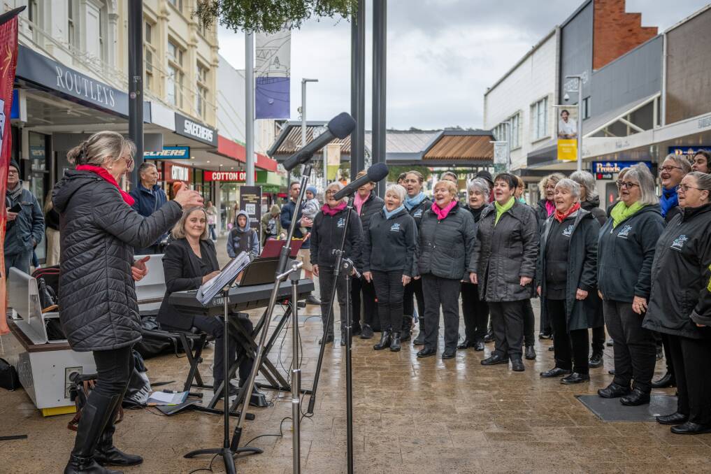 Denise Sam, the Vox Harmony Choir director, leading the choral group in a pop-up performance in the mall. Picture by Craig George