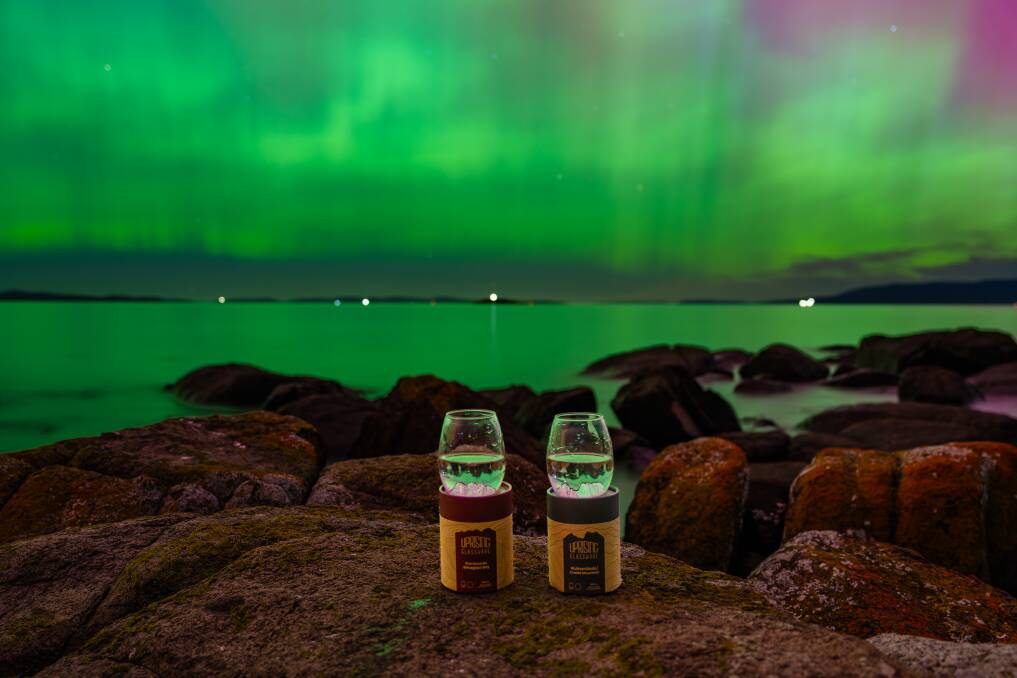 Two of Uprising Glassware's glasses with the recent Aurora Australis event in the background. Picture Marc James Gallery.