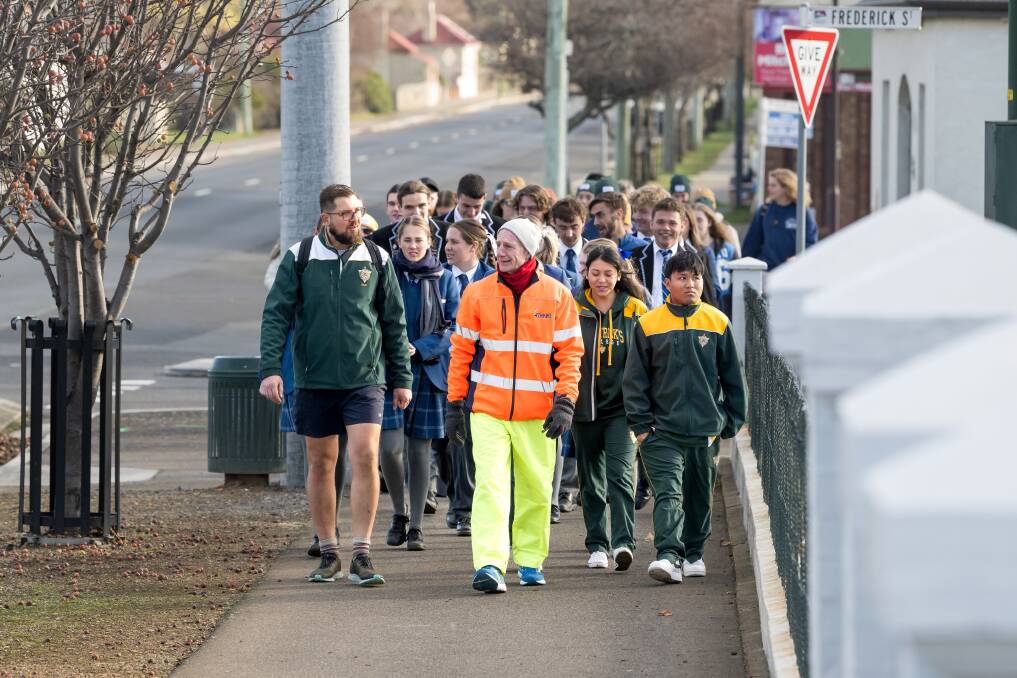 Students and supporters accompany Peter Gutwein as he walks along the main road in Perth on his walk from Burnie to Hobart. Picture by Phillip Biggs