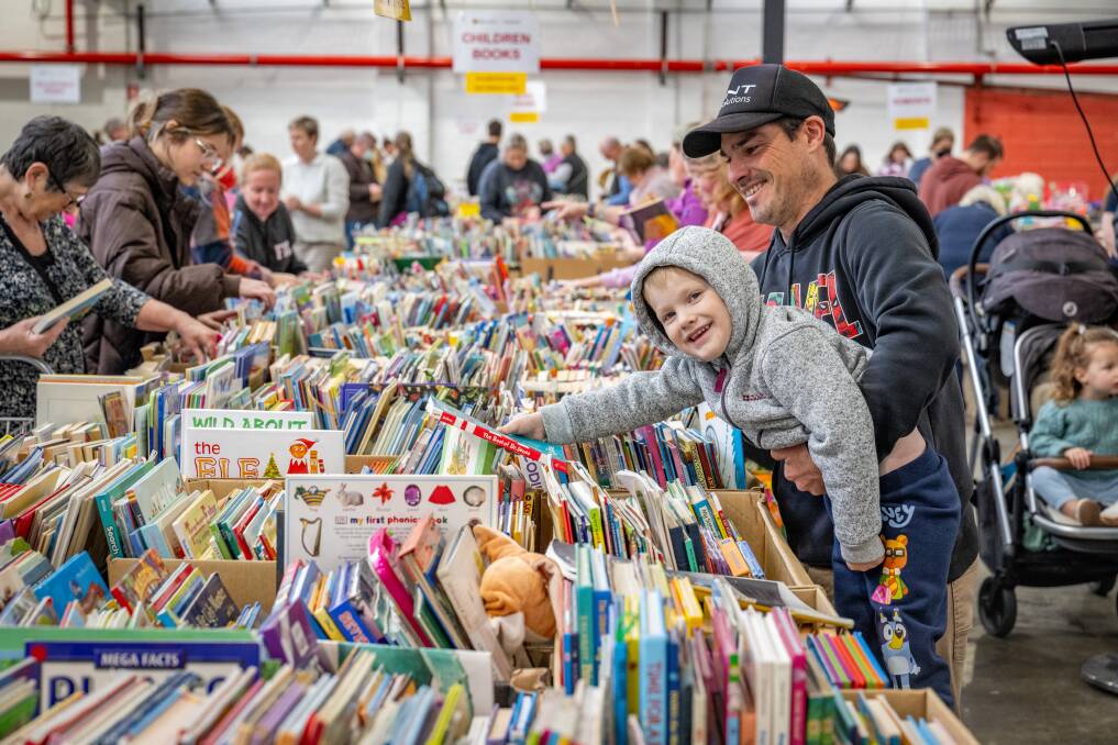 Launceston's Samuel Burrows, 4, and his dad Anthony reach for a classic at Bookfest. Picture by Paul Scambler 