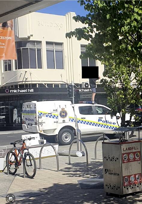 Alleged juvenile offender on top of a police divisional van in Brisbane Mall on Monday.