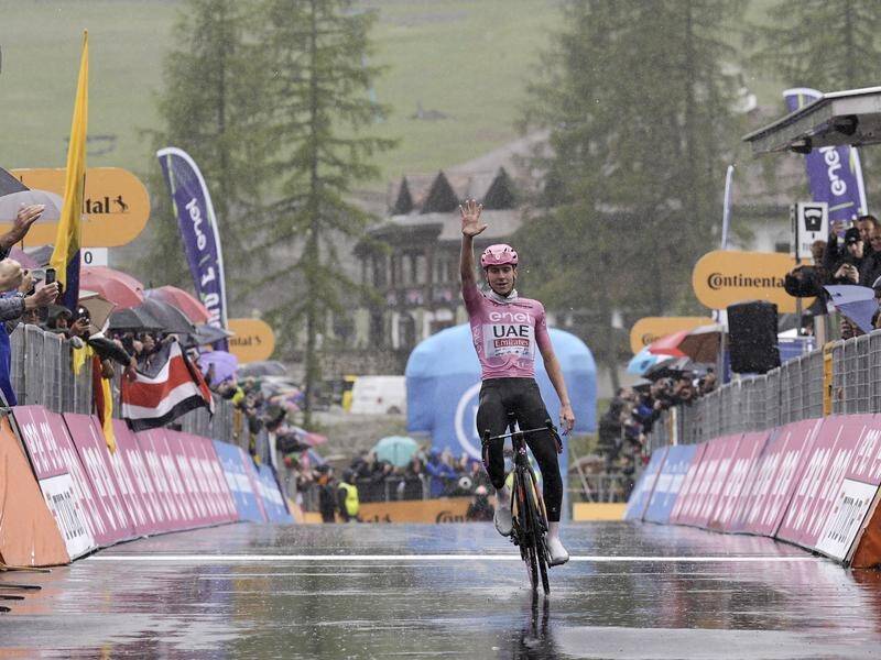 Tadej Pogacar signals a fifth stage win in the Giro d'Italia as he crosses the line in Val Gardena. (AP PHOTO)
