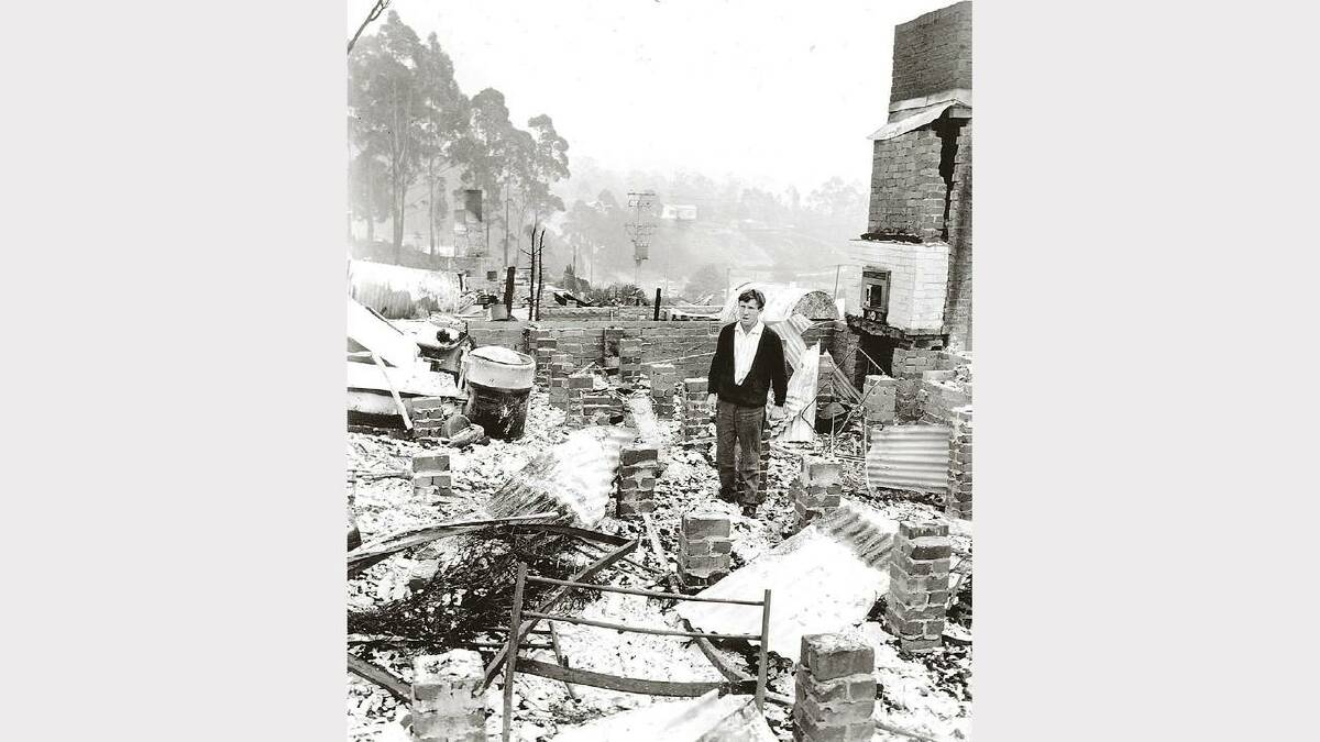 1967 Bushfires: David Burke stands in the ashes of his fiancee's Strickland Avenue home the day after the fires ravaged the area.